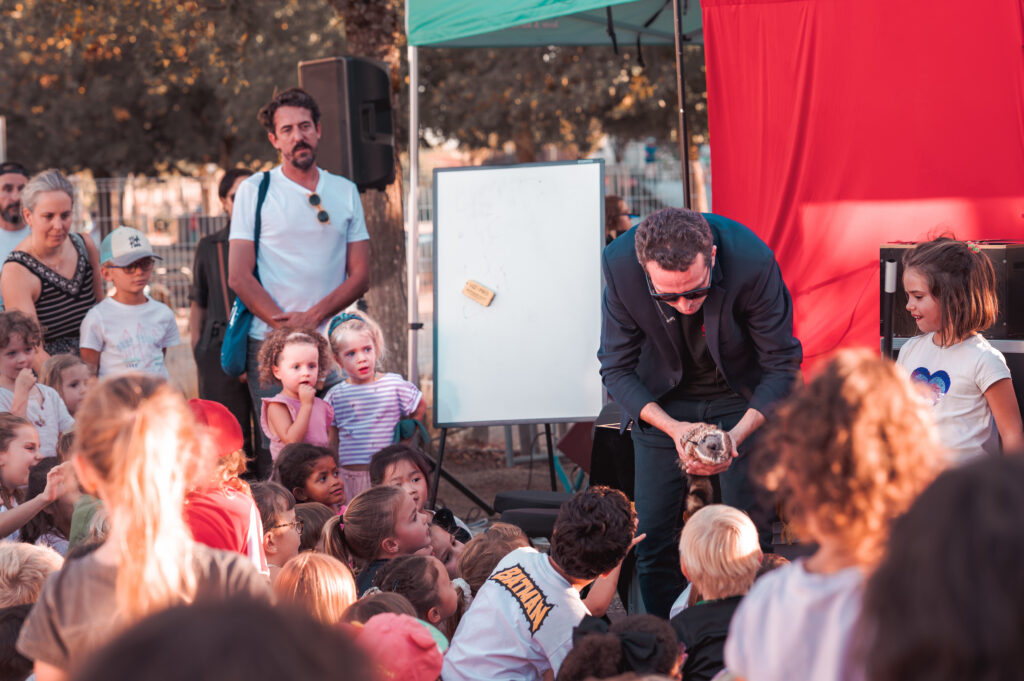Nicolas Cardin faisant participer un enfant pendant un spectacle de magie