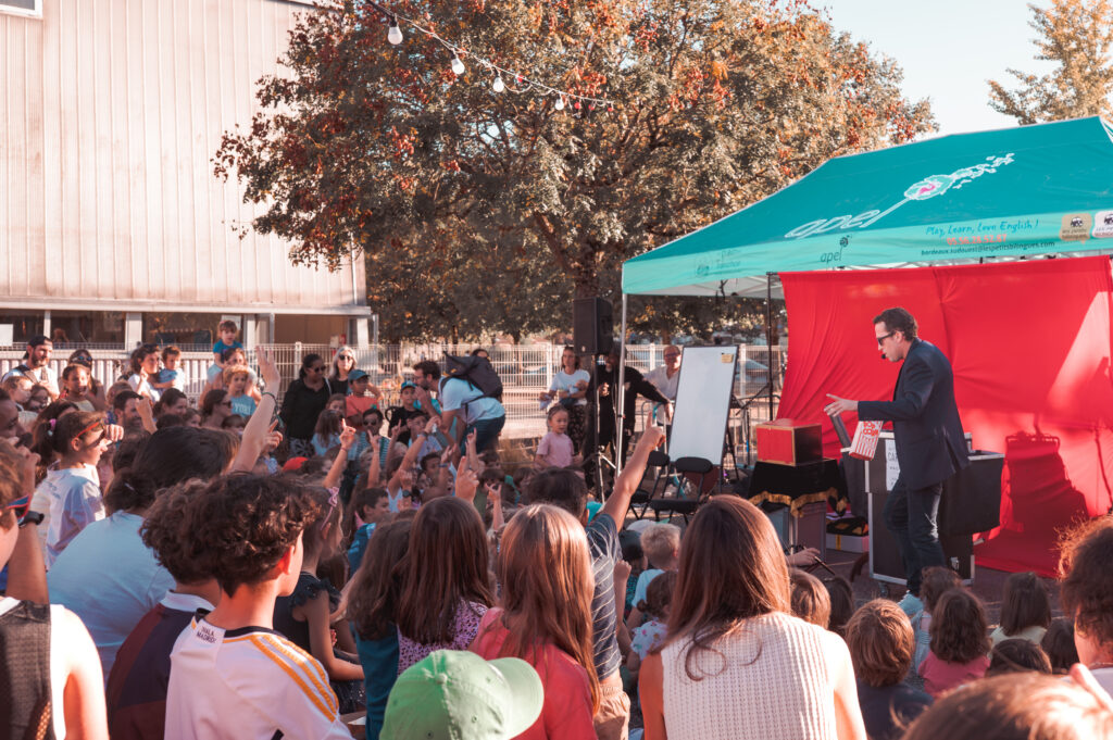 Spectacle de magie en plein air devant une foule d'enfants et de parents, Nicolas Cardin