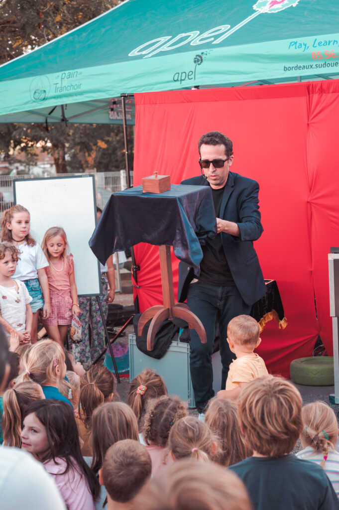 Magicien en spectacle devant un public d'enfants en Gironde