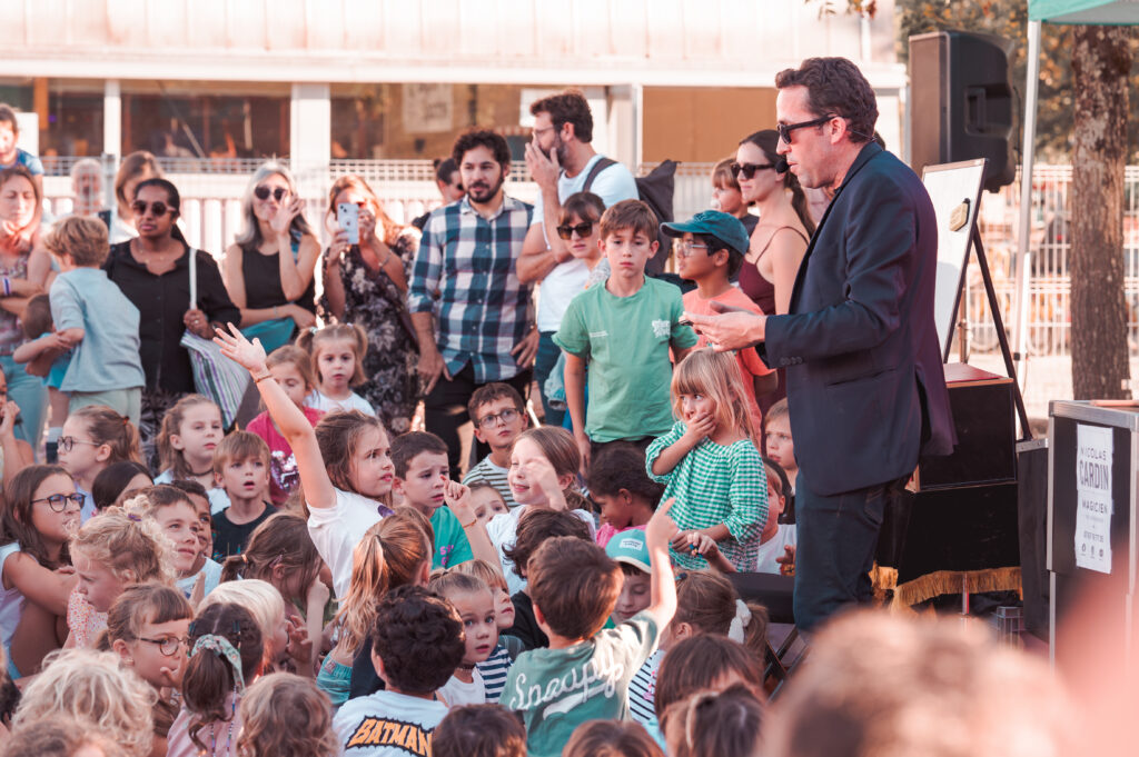 Nicolas Cardin en spectacle de magie devant un public familial, enfants et parents